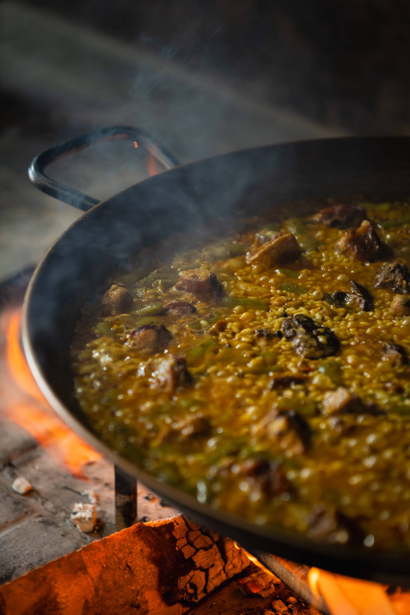 Paella valenciana cocinándose a leña